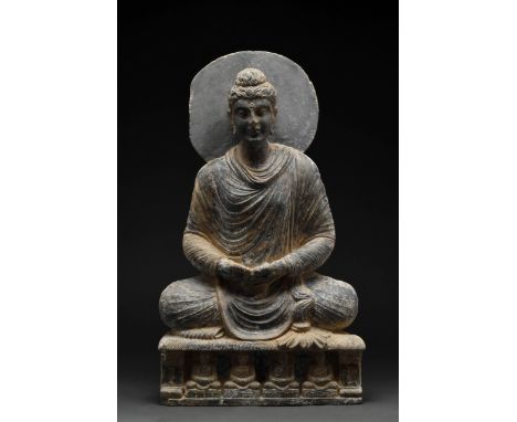 Circa 100-200 AD A beautifully carved schist Buddha seated in a dhyanasana position with his hands folded in his lap, the dee