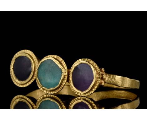 Circa 400-600 AD. A Roman early Byzantine gold double-hooped ring, decorated with various gemstones. Two oval bezels feature 