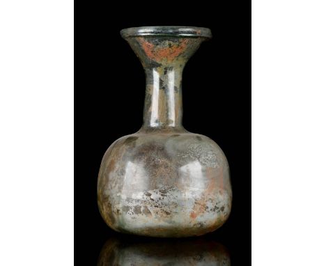 Circa 100-300 AD An elegant ancient glass flask blown into a pale green colour. The vessel features a globular body, an elong