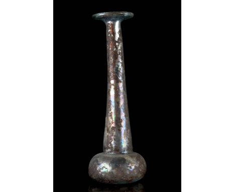 Circa 100 – 300 AD An elegant glass unguentarium in the shape of a candlestick featuring a short globular body sitting on a c