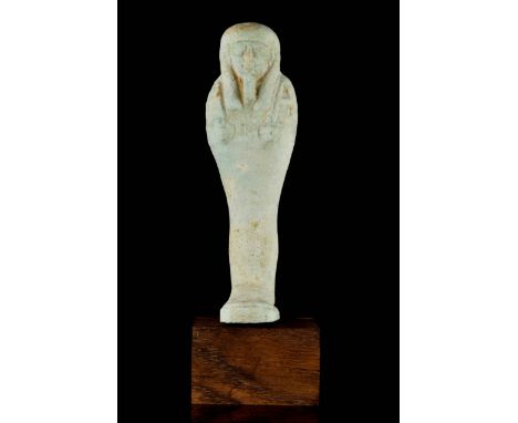 Late Period, circa 332 BC A mummiform ushabti in a light green glazed faience, wearing a plain tripartite wig, and a divine b