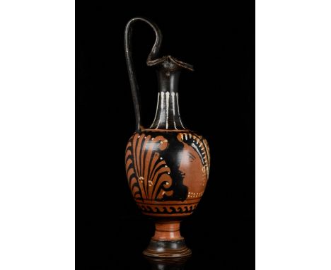 Circa 400 BC. Southern Italian. A beautiful terracotta oinochoe with flaring trefoil rim, elongated neck, sloping shoulder, e