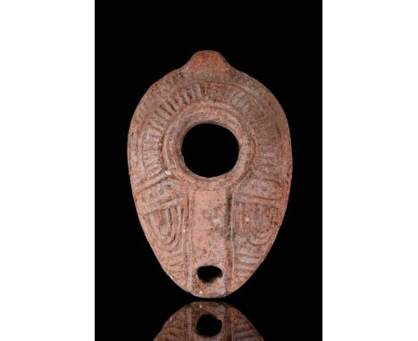 Circa 100-200 AD A pottery oil lamp with convex body, incised floral decoration and hatching around the fill hole and nozzle.