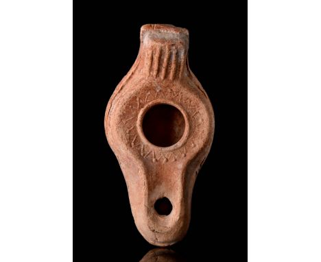 Circa 100 - 200 AD A pottery oil lamp with convex body, incised floral decoration around the fill hole and nozzle, a conical 