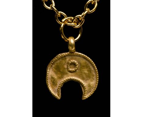 Circa 100 AD. An Ancient Roman gold lunar amulet; composed of a flat section moon crescent body; applied loop; elaborate fili