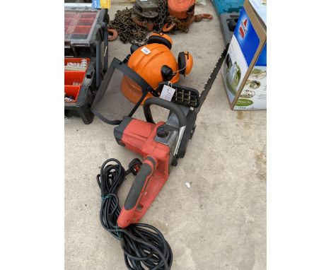 AN ELECTRIC CHAINSAW AND A SAFETY HAT WITH EAR DEFENDERS 