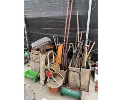 A LARGE QUANTITY OF VINTAGE GARDEN TOOLS TO INCLUDE RAKES, FORKS AND SPADES ETC 