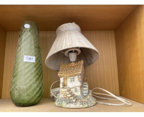 A GREEN GLASS VASE AND A COTTAGE TABLE LAMP 