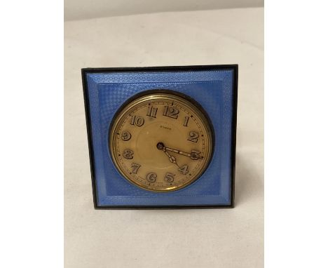 A SWISS MADE 8 DAY TRAVELLING CLOCK IN A BIRMINGHAM HALLMARKED SILVER STAND WITH GUILLOCHE ENAMEL TO FRONT 
