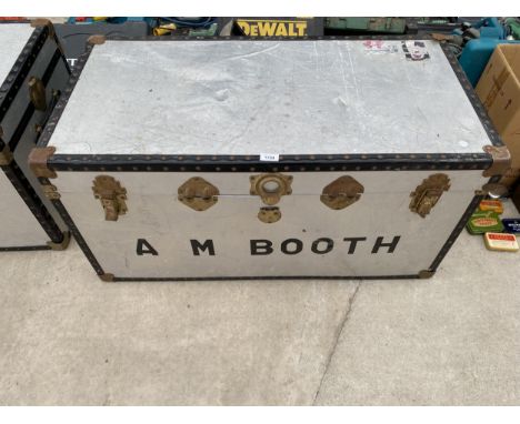 A METAL TRAVEL TRUNK WITH BRASS FITTINGS BEARING THE NAME 'A M BOOTH' 