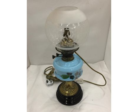 A CONVERTED VINTAGE BRASS OIL LAMP ON BRASS STAND AND SOLID HEAVY BASE WITH PAINTED CERAMIC DECORATION 