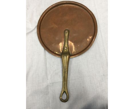 A VINTAGE COPPER SKILLET WITH A BRASS HANDLE 