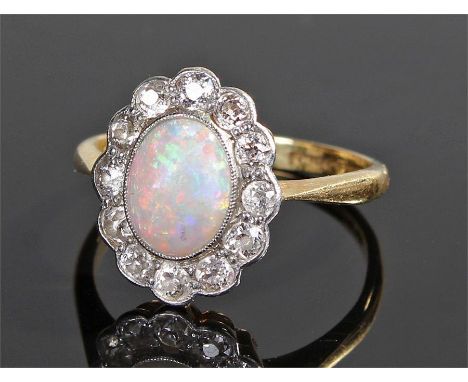 18 carat gold opal and diamond ring, the oval opal with diamond surround, ring size N