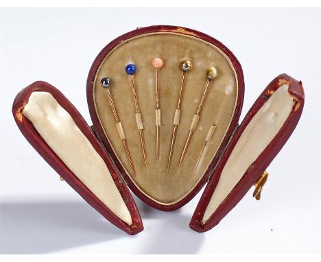 Cased stick pin set, with five pins each with a stone set terminal, housed within the original leather case