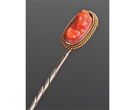 Victorian coral stick pin, with a carved coral cameo head above a mount and pin