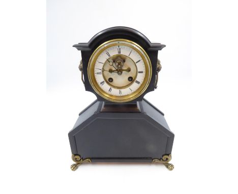 Slate mantle clock with lion mask handles, raised on an ebonised base key and pendulum present, H: 38 cm. Not available for i