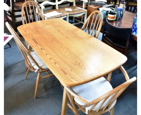 A LIGHT ERCOL PLANK TOP KITCHEN TABLE  and four Ercol stickback Windsor chairs including two carvers