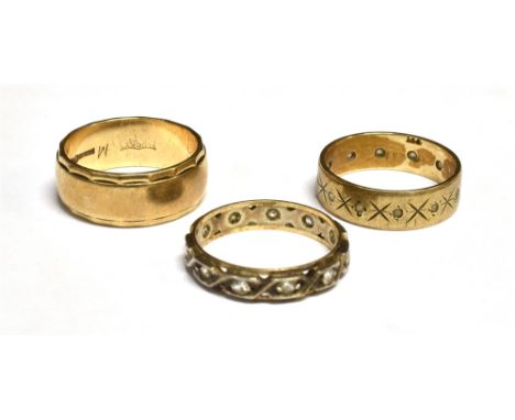 THREE RINGS INCLUDING A 9CT GOLD BROAD WEDDING BAND with facetted borders, London 1973, 7mm wide, size leading edge M, 5g; a 