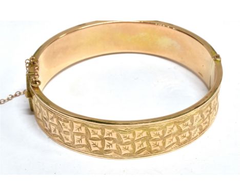 AN EARLY 20TH CENTURY 9CT ROSE GOLD PART FOLIATE ENGRAVED HOLLOW BANGLE  of hinged rectangular section, Birmingham 1913, 14.7