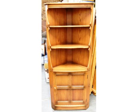 AN ERCOL 'GOLDEN DAWN' CORNER CABINET  with two shelves above cupboard, 75cm wide 184cm high