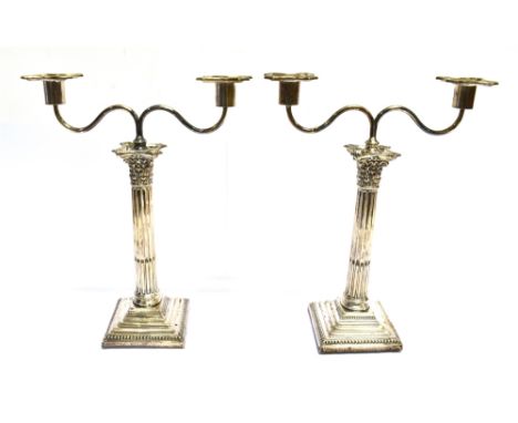 A PAIR OF SILVER CORINTHIAN COLUMN CANDLE STICKS WITH LATER PLATED TWO BRANCH CANDELABRA SURMOUNT the sticks with acanthus ca
