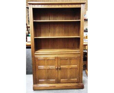 AN ERCOL 'GOLDEN DAWN' BOOKCASE  with three adjustable shelves above cupboard, 94cm wide 34cm deep 155cm high