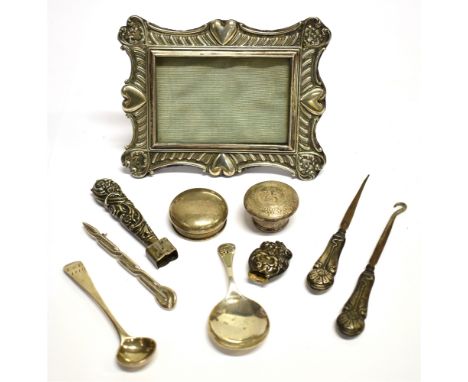 A LATE VICTORIAN SMALL SILVER MOUNTED PHOTOGRAPH FRAME AND OTHER SMALL SILVER ITEMS the shaped-rectangular easel-back photogr