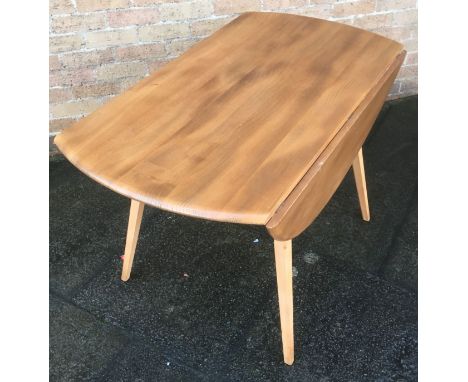 AN ERCOL LIGHT ELM DROP LEAF TABLE  the oval top 113cm x 124cm (64cm with leaves down)