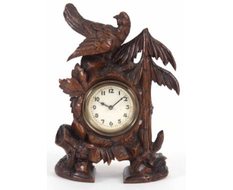 A CARVED BLACK FORREST MANTEL CLOCK with bird on a tree 19 cm high