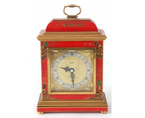 ELLIOTT, LONDON. A RED LACQUERED CHINOISERIE MANTLE CLOCK with caddy top and hinged brass handle, oriental figures to the sid