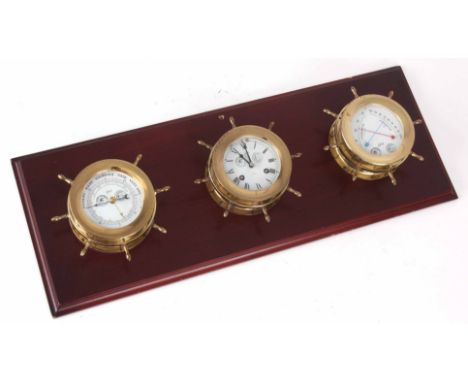 A LATE 20th CENTURY SHIPS WEATHER STATION the three brass cases formed as ships wheels enclosing a barometer, clock, and ther