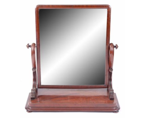 A LARGE MAHOGANY TOILET MIRROR with carved scroll end supports and shelf base, standing on moulded plinth 79cm wide 84cm high