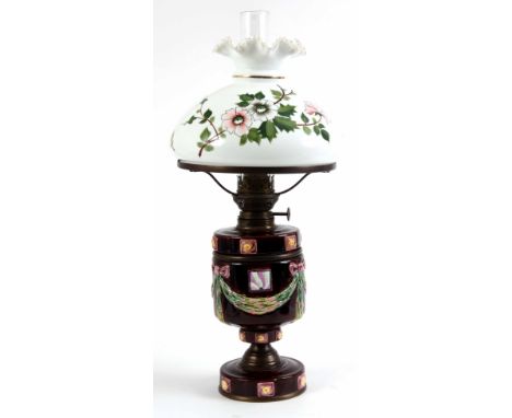 A 19TH CENTURY MAJOLICA OIL LAMP with swag and jewelled decoration; the large white shade decorated with leaf-work and flower