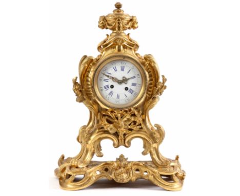 A LATE 19TH CENTURY FRENCH ORMOLU MANTLE CLOCK with urn finial applied with lion masks above the rococo style case with acant