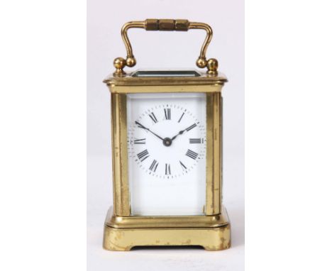 A FRENCH BRASS CASED MINIATURE CARRIAGE CLOCK with hinged carrying handle and bevelled glass panels enclosing a 1.25" porcela
