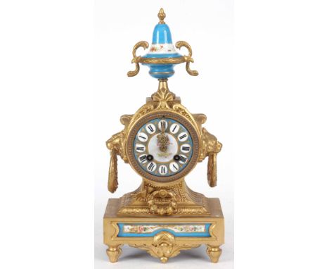 A LATE 19th CENTURY FRENCH GILT CASED MANTLE CLOCK surmounted with porcelain urn finial the case inset with floral painted po