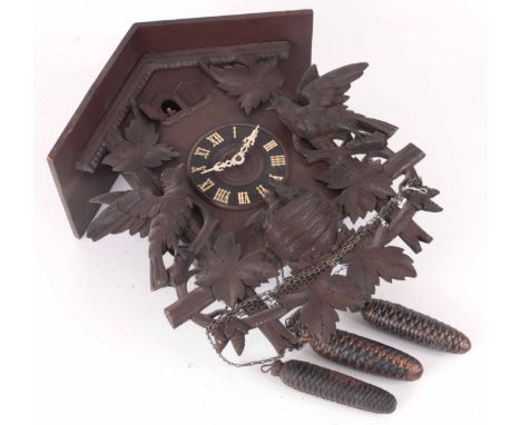 A CARVED BLACK FOREST CARVED CUCKOO CLOCK WITH MUSICAL MOVEMENT the case decorated with leaf work and birds with nest, the 5.