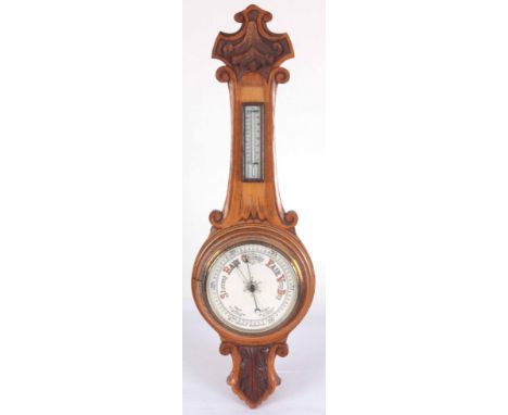 AN EARLY 20th CENTURY WALL ANEROID BAROMETER AND THERMOMETER IN A CARVED OAK CASE 90cm high