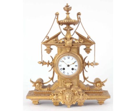 A LATE 19th CENTURY FRENCH ORMOLU MANTLE CLOCK with architectural style top surmounted with large urn finial on a scrollwork 