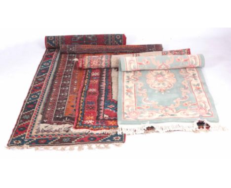 FOUR RUGS one eastern runner with red ground 270cm long 76cm wide one rug on orange ground 148cm long 92cm wide, one red and 