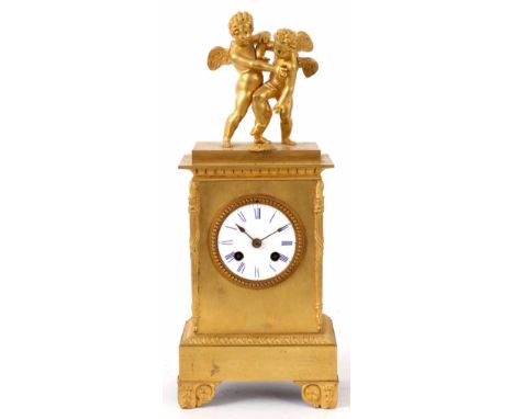 A FRENCH LATE 19th CENTURY ORMOLU MANTEL CLOCK of rectangular form with torch decoration to the corners surmounted with two c