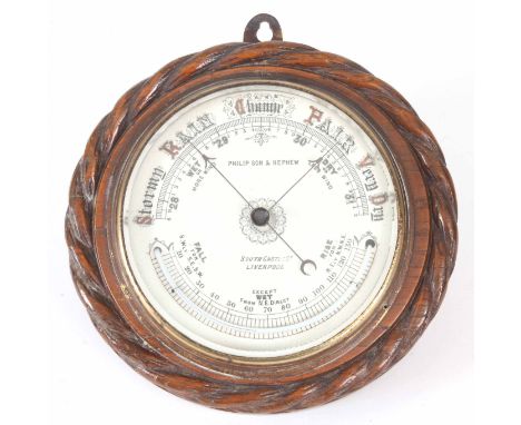A LATE 19th CENTURY PORCELAIN DIAL ANEROID BAROMETER with curved thermometer enclosed with oak rope edge surround 24cm diamet