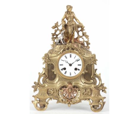 A LATE 19TH CENTURY FRENCH BRASS ORMOLU ROCOCO STYLE MANTLE CLOCK with figure of a female hunter with her dog. The 3” enamel 