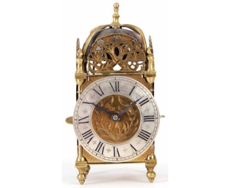 AN EARLY 20th CENTURY BRASS LANTERN STYLE MANTEL CLOCK of typical form with silvered engraved Roman chapter ring and engraved