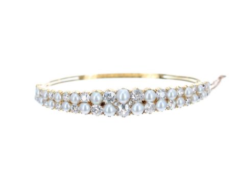 Good Victorian yellow gold multi-diamond and pearl set hinged bangle, with twenty-four graduated round-cut diamonds and twent