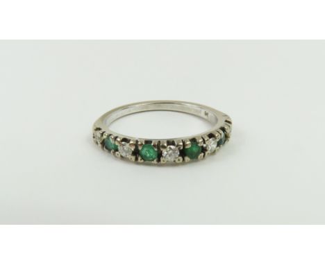 An 18ct white gold emerald and diamond half eternity ring, finger size O, 2.67g gross