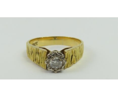 A diamond single stone ring, with bark patterned shoulders, marked '18ct', finger size K, 3.44g gross