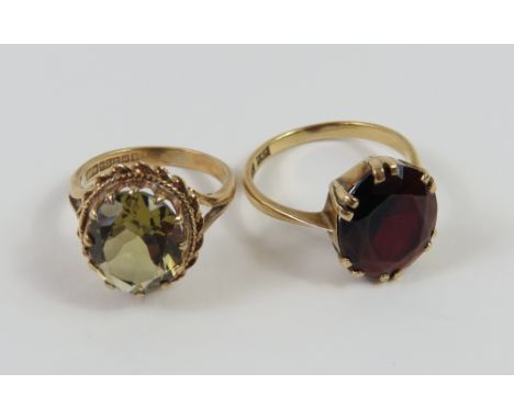 A 9ct gold pale green stone ring, with twisted rope border, finger size M and a garnet cocktail ring, marked '9ct', finger si