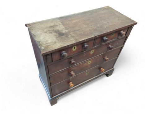A stained oak chest of two short and three long drawers, of small proportions, with round turned handles and on bracket feet,