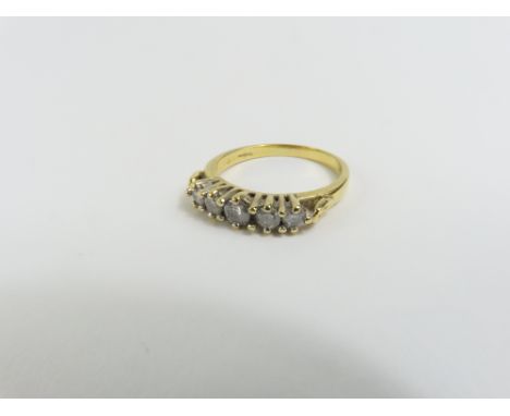 An 18ct gold graduated diamond five stone ring, with decorative raised shoulders, finger size O 1/2, 4.15g gross